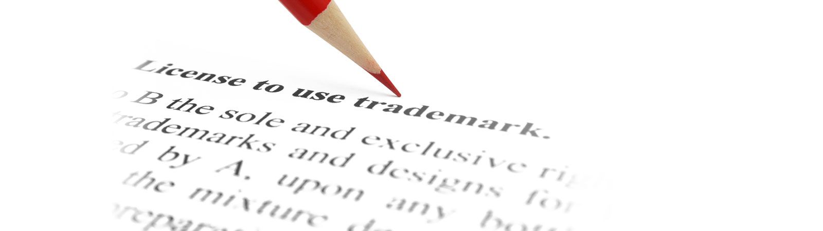 Red pencil pointing at the heading "License to use trademark" on a legal document